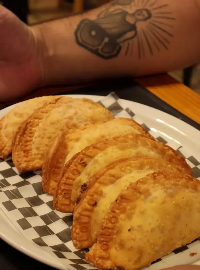 Empanadas doradas sobre papel a cuadros